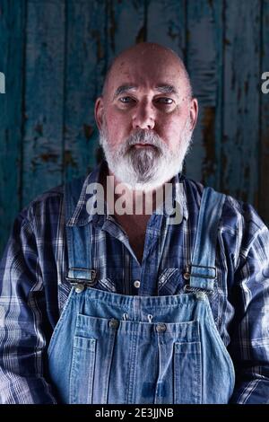 Porträt eines älteren Mannes in Lätzchen Overalls. Stockfoto