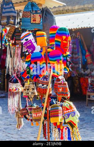 Bunte Strickmasken und Hüte zum Verkauf in einem Souvenirstand. Ollantaytambo im Heiligen Tal in Urubamba, Cusco Region, Südperu Stockfoto