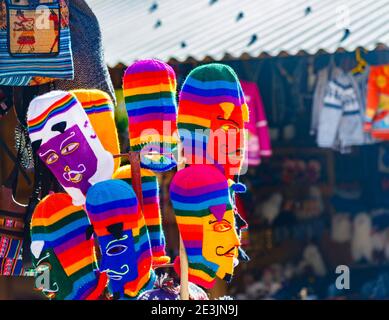 Bunte Strickmasken und Hüte zum Verkauf in einem Souvenirstand. Ollantaytambo im Heiligen Tal in Urubamba, Cusco Region, Südperu Stockfoto