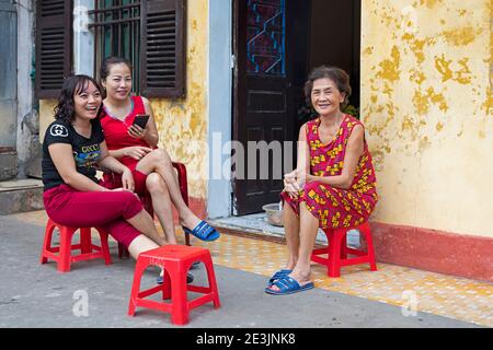 Vietnamesische Frauen sitzen und plaudern vor ihrem Haus In der Stadt Ninh Binh im Red River Delta Nordvietnam Stockfoto