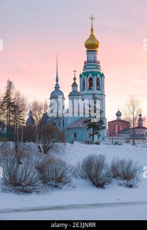 Die Alexander-Newski-Kirche und der Glockenturm der Sophienkathedrale vor dem Hintergrund eines Sonnenuntergangs im März. Wologda, Russland Stockfoto