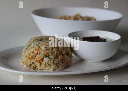 Dalia Upma oder Broken Wheat Upma ist ein südindisches Frühstück mit gebrochenem Weizen, mischen Gemüse und andere grundlegende Temperierung Zutaten serviert mit Stockfoto