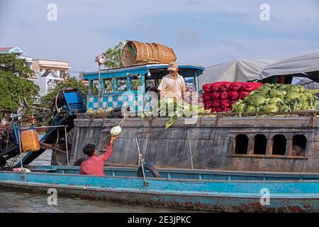 Vietnamesischer Landwirt, der Gemüse von traditionellen Holzbooten auf dem schwimmenden Markt der Stadt Can Tho im Mekong Delta, Vietnam verkauft Stockfoto