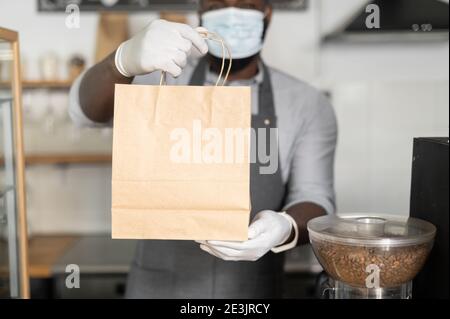 Ein afrikanischer Kellner in einer medizinischen Maske Stockfoto