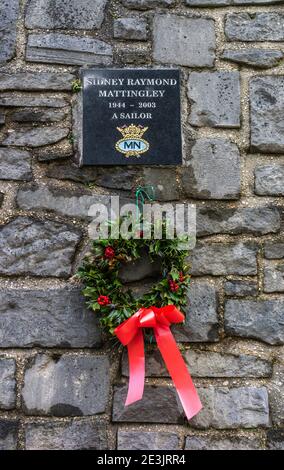 Ein Weihnachtskranz hing unter einem Denkmal für Sidney Raymond Mattingley, Merchant Navy Seemann, der 2003 starb, Holyrood Church, Southampton, Großbritannien Stockfoto