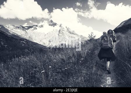 Junges Paar beim Wandern in den französischen Alpen im Sommer. Der Aiguille des Glaciers, Berg im Mont Blanc Massiv. Savoie, Frankreich. Schwarz-weiß Stockfoto