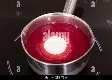 Der Prozess der Herstellung von roten süßen Sirup. Nahaufnahme. Stockfoto