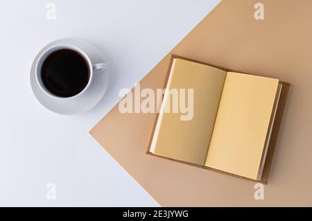 Tasse Kaffee und Tagebuch. Minimalismus und Bürokonzept. Flach liegend. Draufsicht. Stockfoto