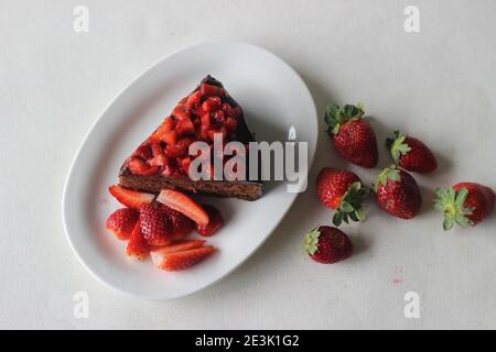 Schokoladenkuchen Scheibe mit Schokolade Ganache und garniert mit frischen Erdbeeren für einen Valentinstag und ein Weihnachtsfest Stockfoto