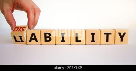 Haftungs- oder Behindertensymbol. Geschäftsmann dreht Würfel und ändert das Wort "Haftung" zu "Disability". Schöner weißer Hintergrund. Business, liabil Stockfoto