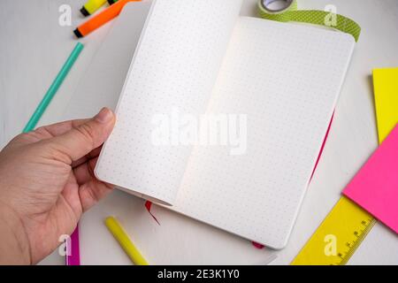 Nahaufnahme der Hände von Frauen, die gepunktete Seiten des Bullet-Journalplaners nehmen. Konzept für Planung und Organisation Stockfoto