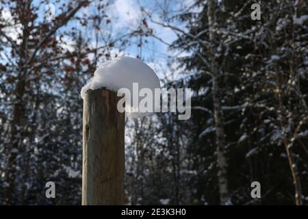 Weiße Schneekappen an den Zaunpfosten. Stockfoto
