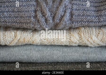 Stapel von kuschelig gestrickten grauen Pullovern. Retro-Style. Warmes Konzept Stockfoto