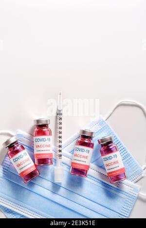 Drei Impfglasflaschen zur Impfung gegen COVID-19 und Spritzen Stockfoto