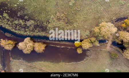 Blick auf den Fluss, der nach der Ernte durch Felder fließt. Stockfoto