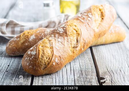 Zwei knusprige frische Baguettes auf einem Holztisch. Stockfoto