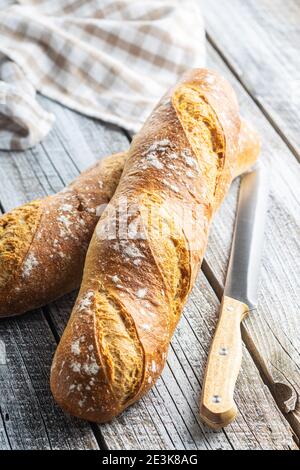 Zwei knusprige frische Baguettes auf einem Holztisch. Stockfoto