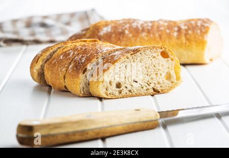 Knusprige frische Baguettes. Baguette in Scheiben auf weißem Tisch. Stockfoto