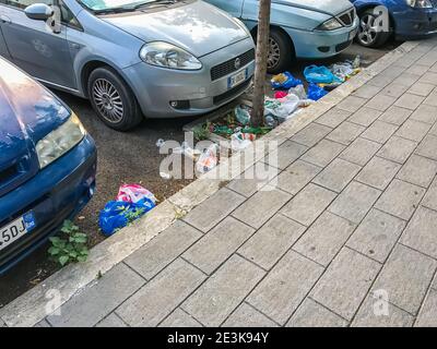Müll, Umweltverschmutzung. Stapel von Verpackungen und Plastikflaschen liegt mitten auf der Straße in der Nähe von Autos. Rom, Italien, 18. Juni 2017 Stockfoto