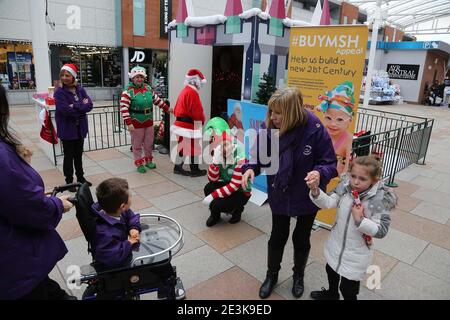 Ayr, Ayrshire, Schottland, Großbritannien. Ayr Central Shopping Centre, eine erschöpfte, aussehende Frau, die als Elfe verkleidet ist, sieht gestresst aus, wenn sie in einer Weihnachtsgrotte hilft. Stress, Müdigkeit, Stockfoto