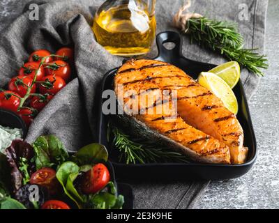 Gegrillter Steak Fisch Lachs, Forelle in einer Grillpfanne, Gewürze, Rosmarin, Tomate Stockfoto