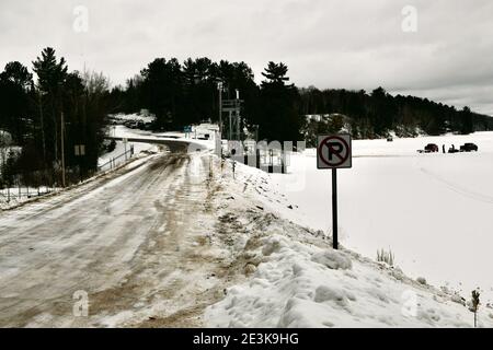 Menschen, die sich nach einem Wintersturm bereit machen, Eisfischen und Motorschlittenfahrten auf einem gefrorenen Wintersee und Staudamm im Norden von Minnesota zu machen. Stockfoto