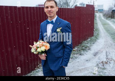 Bräutigam in einem blauen Kleid hält einen Blumenstrauß in ihren Händen, die Hochzeitstradition ist es, einen Blumenstrauß an die Mädchen zu werfen, frische Blumen br Stockfoto