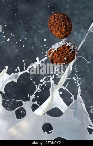 Haferflocken mit Milchspritzern auf grauem Hintergrund. Levitation Stockfoto