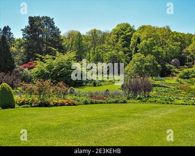 Blick über grüne Rasenflächen, Blumenbeete und Bäume in Harlow Carr Gardens, Harrogate, North Yorkshire im Sommer ohne Menschen im Blick Stockfoto