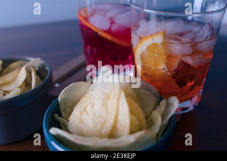 Zwei Spritz mit ein paar Chips auf dem Tisch bereit für den Aperitif während der Happy Hour . Ein Sprtiz wird mit aperol und einer mit Campari gemischt. Hohe Qual Stockfoto