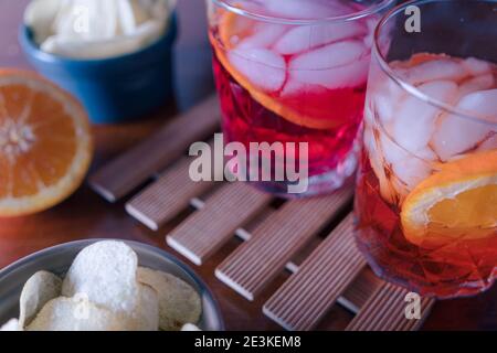 Zwei Spritzer mit einigen Chips auf dem Tisch bereit für die Vorspeise. Ein Sprtiz wird mit aperol und einer mit Campari gemischt. Hochwertige Fotos Stockfoto