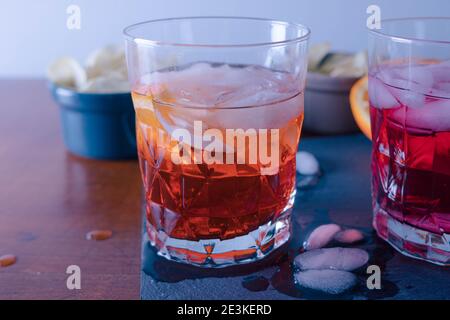 Zwei Spritz mit einigen Chips auf dem Tisch bereit für den Aperitif, wird die Orangeone mit Aperol gemischt. Ein Sprtiz wird mit aperol und ein Sprtiz mit campa gemischt Stockfoto