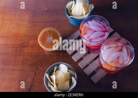 Zwei Spritz mit einigen Chips auf dem Tisch bereit für den Aperitif. Ein Sprtiz wird mit aperol und einer mit Campari gemischt. Hochwertige Fotos Stockfoto