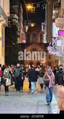 Menschen mit Gesichtsmasken auf der Ermou Straße, der Haupteinkaufsstraße in Athen, Griechenland bei Nacht Stockfoto