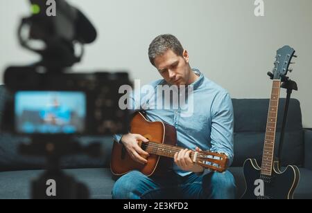 Mann mit spanischer Gitarre vor der Videokamera. Stockfoto