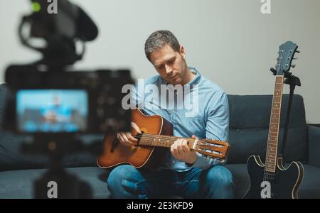 Mann mit spanischer Gitarre vor der Videokamera. Stockfoto