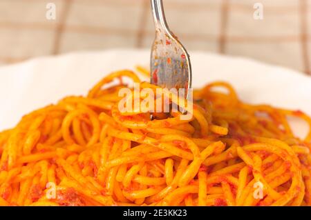 Nahaufnahme einer Gabel, die auf einer Platte von ist Spaghetti Bolognese mit Fleisch und Tomaten Stockfoto