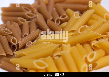 Nahaufnahme von Vollkornpasta in Form von Vollkorn und normal Makkaroni aus Weizen Stockfoto