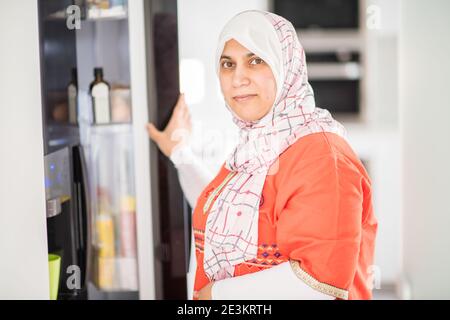 Muslimische arabische traditionelle Frau in der Küche, die Essen zubereitet Stockfoto