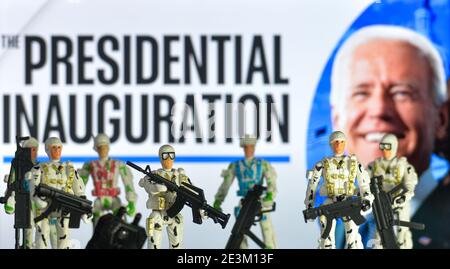In dieser Fototafel die Spielzeugsoldaten, die vor der Werbung für die Amtseinführung des Präsidenten zu sehen sind, mit dem Bild des gewählten US-Präsidenten Joe Biden, das auf einem Bildschirm im Hintergrund zu sehen ist. Stockfoto
