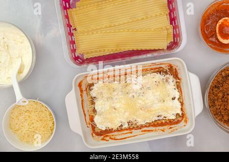 Rindfleisch Lasagne Schritt für Schritt Rezept. Lasagne zusammenbauen. Flache Laie, Marmor Küchentisch Hintergrund Stockfoto