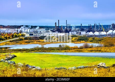 Ein Herbstbild der großen Ölraffinerie Irving im ländlichen Saint John New Brunswick, Kanada, mit dem lokalen Laub, das die leuchtenden Farben des Herbstes färbt. Stockfoto