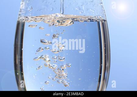 Wasserblase Splash abstrakt in reinem Glas, transparente Weinglas auf Sonnenlicht, natürliche blaue Welle Hintergrund Fotografie Stockfoto