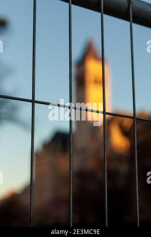 Washington, DC, USA, 19. Januar 2021. Im Bild: Sicherheitszaun vor dem Turm des Old Post Office, der jetzt das Trump Hotel ist, bei Sonnenuntergang. Der Zaun und die untergehende Sonne schienen Metaphern für die Trump-Administration zu sein, die etwa 18 Stunden nach der Aufnahme endet. Könnte Donald Trump auch hinter Gittern landen? Kredit: Allison C Bailey/Alamy Live Nachrichten Stockfoto