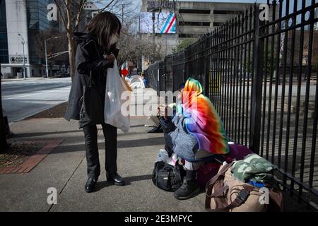 Atlanta, Georgia, USA. Atlanta, GA, USA. Januar 2021. Sharon Walker, eine Mitarbeiterin der Staatsregierung, gibt in ihrer Mittagspause Getränke an Obdachlose in der Nähe des Georgia State Capitol aus. Kredit: ZUMA Press, Inc./Alamy Live Nachrichten Stockfoto