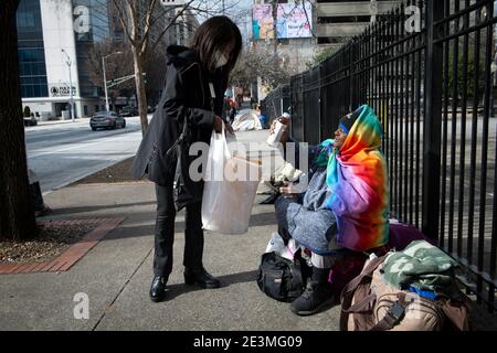 Atlanta, Georgia, USA. Atlanta, GA, USA. Januar 2021. Sharon Walker, eine Mitarbeiterin der Staatsregierung, gibt in ihrer Mittagspause Getränke an Obdachlose in der Nähe des Georgia State Capitol aus. Kredit: ZUMA Press, Inc./Alamy Live Nachrichten Stockfoto