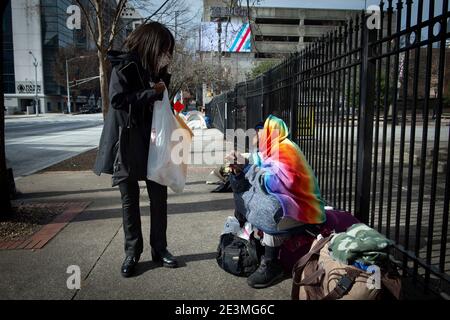 Atlanta, Georgia, USA. Atlanta, GA, USA. Januar 2021. Sharon Walker, eine Mitarbeiterin der Staatsregierung, gibt in ihrer Mittagspause Getränke an Obdachlose in der Nähe des Georgia State Capitol aus. Kredit: ZUMA Press, Inc./Alamy Live Nachrichten Stockfoto