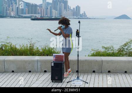 Hongkong November 29 2020 : Frau Street Performer Tragen Maske und Gesang im West Kowloon Kulturbezirk während Coronavirus (COVID-19) Ausbruch Stockfoto