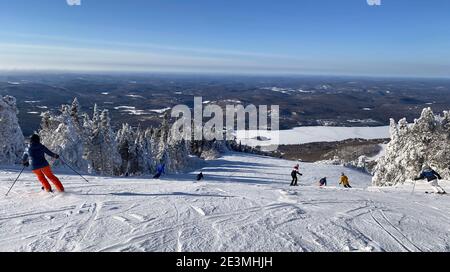 Panorama-Luftaufnahme von Mont Tremblant und See im Winter mit Skifahrern auf Piste Abfahrt, Quebec, Kanada Stockfoto