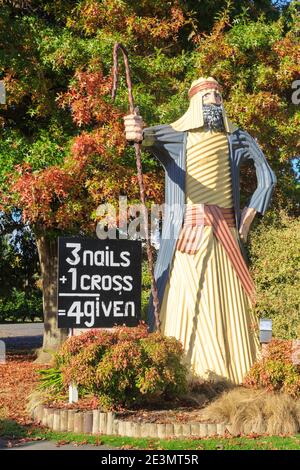 Eine "gute Hirtenstatue" aus Wellblech vor einer Kirche in Tirau, Neuseeland. Die Stadt ist berühmt für ihre Wellblechkunst Stockfoto